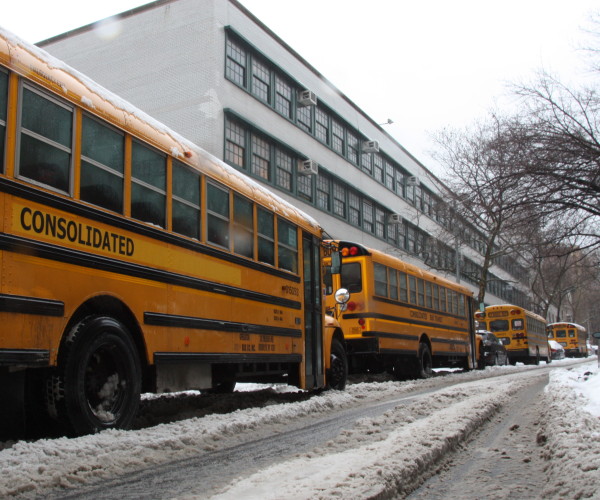 School buses wait for students to get out of school on 77th street and Columbus Avenue. Many parents said they feared it was not safe to send their kids to school as drivers might slide because of the snow. 
