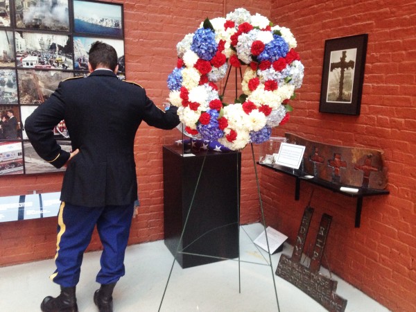 A firemen looks at photos from Ground Zero at the Fire Museum 9/11 Memorial Ceremony. NYCityLens/Shannon Luibrand.