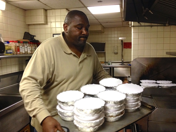 Raleigh Jenkins, 52, takes hot meals out of the oven to serve to the neighborhood's needy.