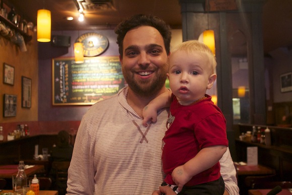 E.J. Cory and his one-year-old son Calvin at their favorite neighborhood bar. (Isabelle Muge Niu/NY City Lens)  