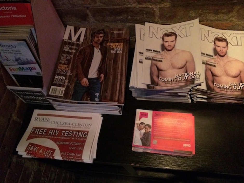 Gay lifestyle publications and PrEP informational postcards on a side table at Therapy bar in Hell's Kitchen. (Daniela Porat/ NY City Lens)
