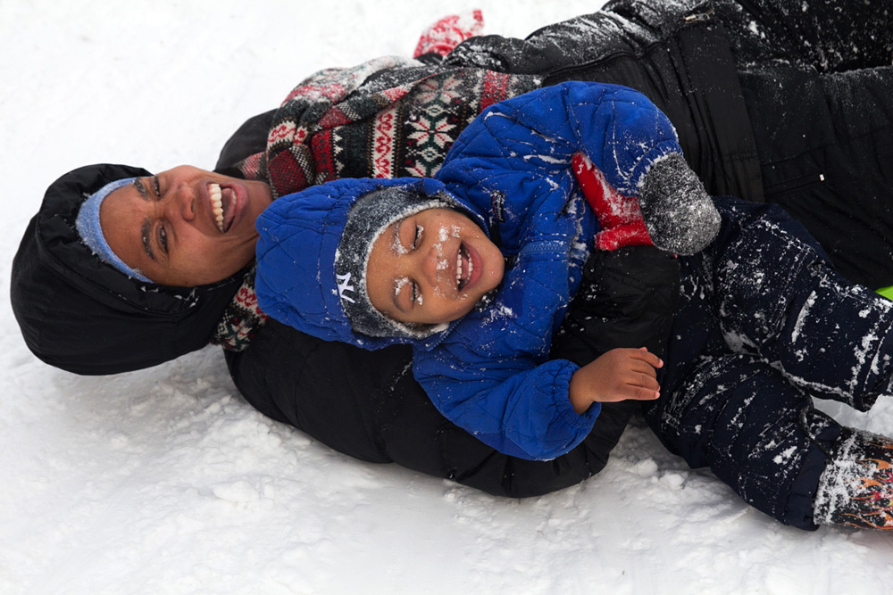 Nanny Alex-Ann Espert holds on to one-year-old Tatum Evans after falling off the sled they were riding.