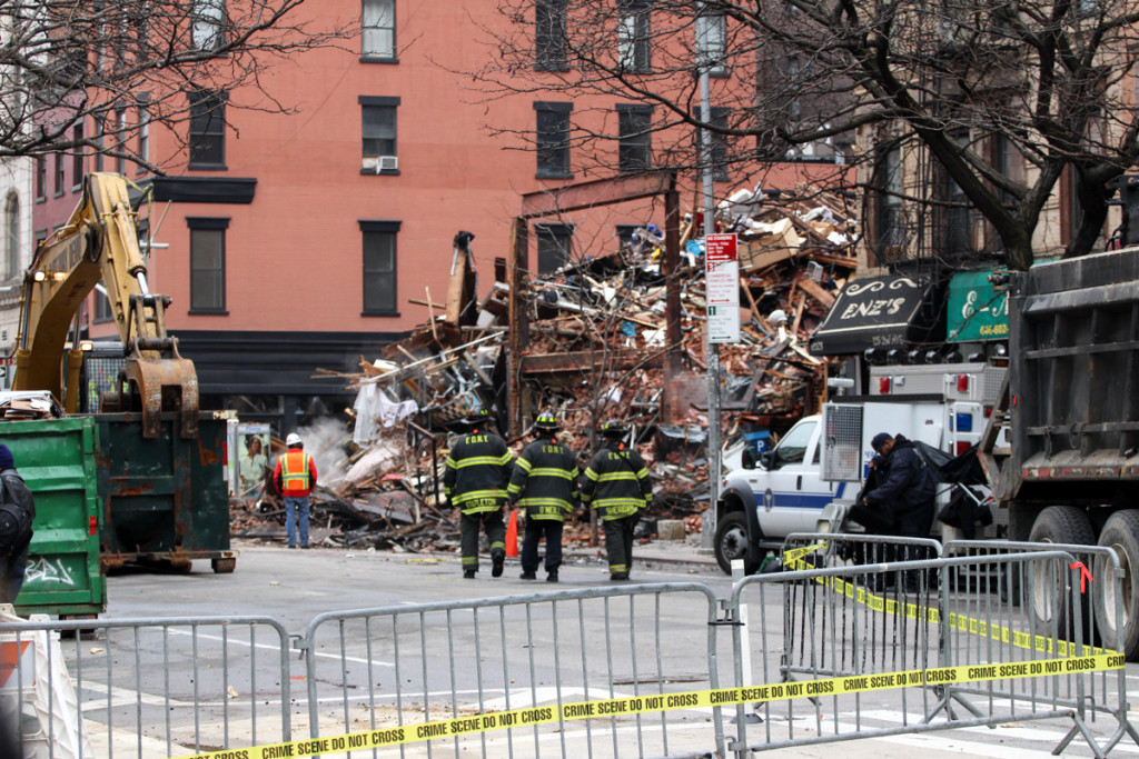 Firefighters walk toward what's left of three buildings after they were leveled due to a gas explosion in the East Village neighborhood of Manhattan, New York, on Friday, March 27, 2015.