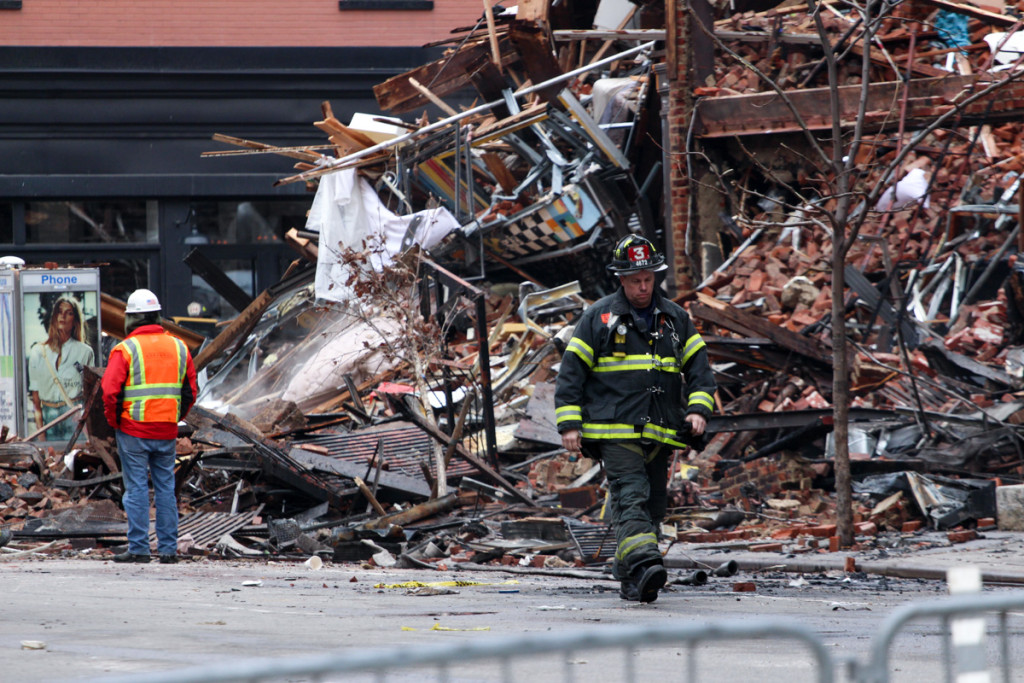 A firefighter walks away from what's left of three buildings after a gas explosion in the East Village on Friday, March 27, 2015. (Solange Uwimana / NY City Lens)