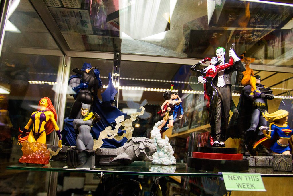 Figurines of famous comic book characters and their significant others line the stop shelf of a glass display case at The Spider’s Web comic book store in Yonkers.