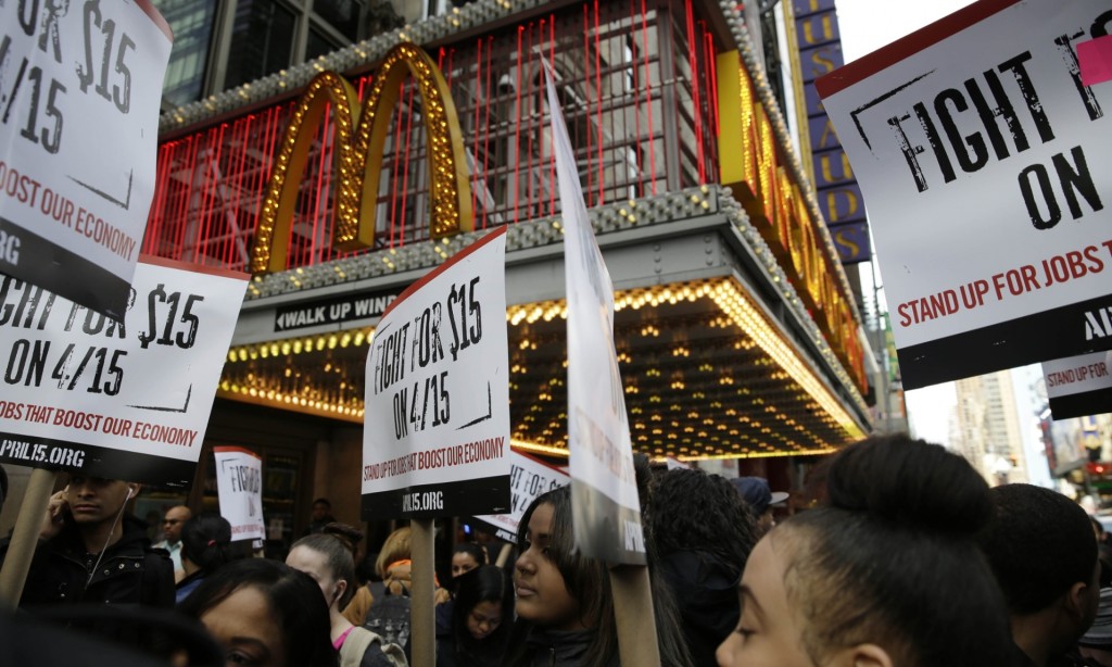 People participate in rally in front of a McDonalds .