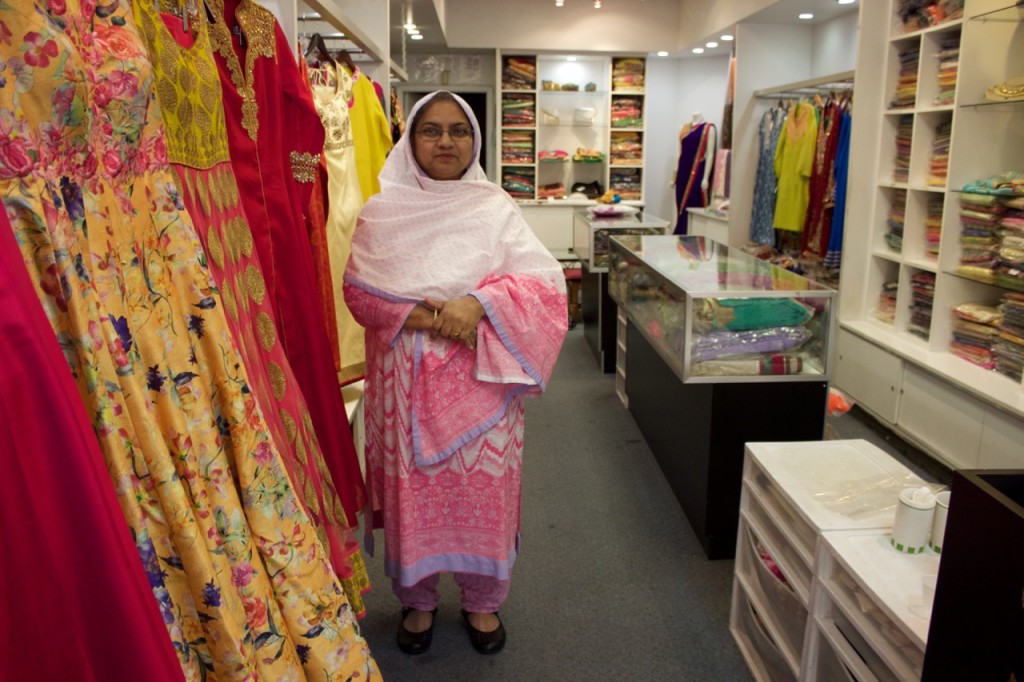 In her boutique in Jackson Heights, Queens, Nasreen Rahman poses next to some of the dresses she is most proud of, on Oct. 21, 2015.