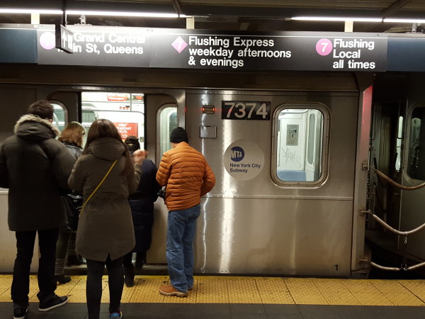 Commuters enter the 7 Train towards Flushing, Queens.