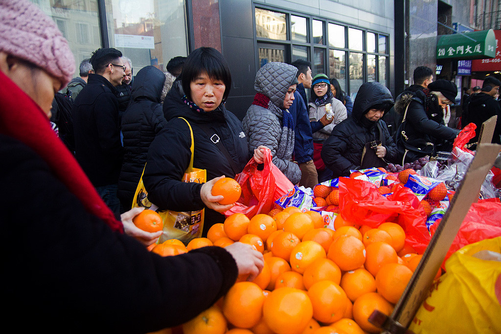 People lined up for buying oranges at street vendors' in Chinatown before Lunar New Year. In China, orange symbolizes good luck