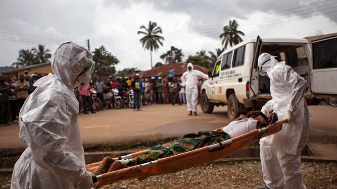 Healthcare workers carry a man suspected of suffering from the Ebola virus onto an ambulance in Sierra Leone. (AP Photo/ Tanya Bindra, File)
