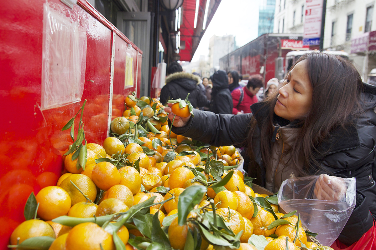Customers select oranges in front of Hong Kong Supermarket on January 27, Chinese New Year’s Eve. (Photo by Zhiming Zhang/ NY City Lens)