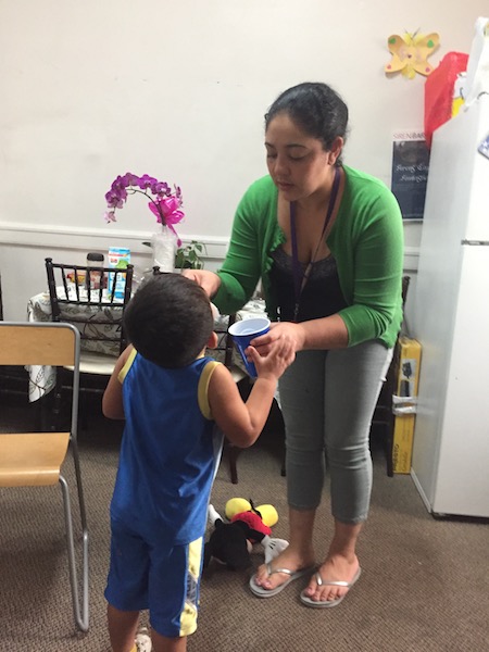 Amanda Morales Guerra feeds cough medicine to her two-year-old son, David, at Holyrood Episcopal Church on Tuesday, Sept. 12