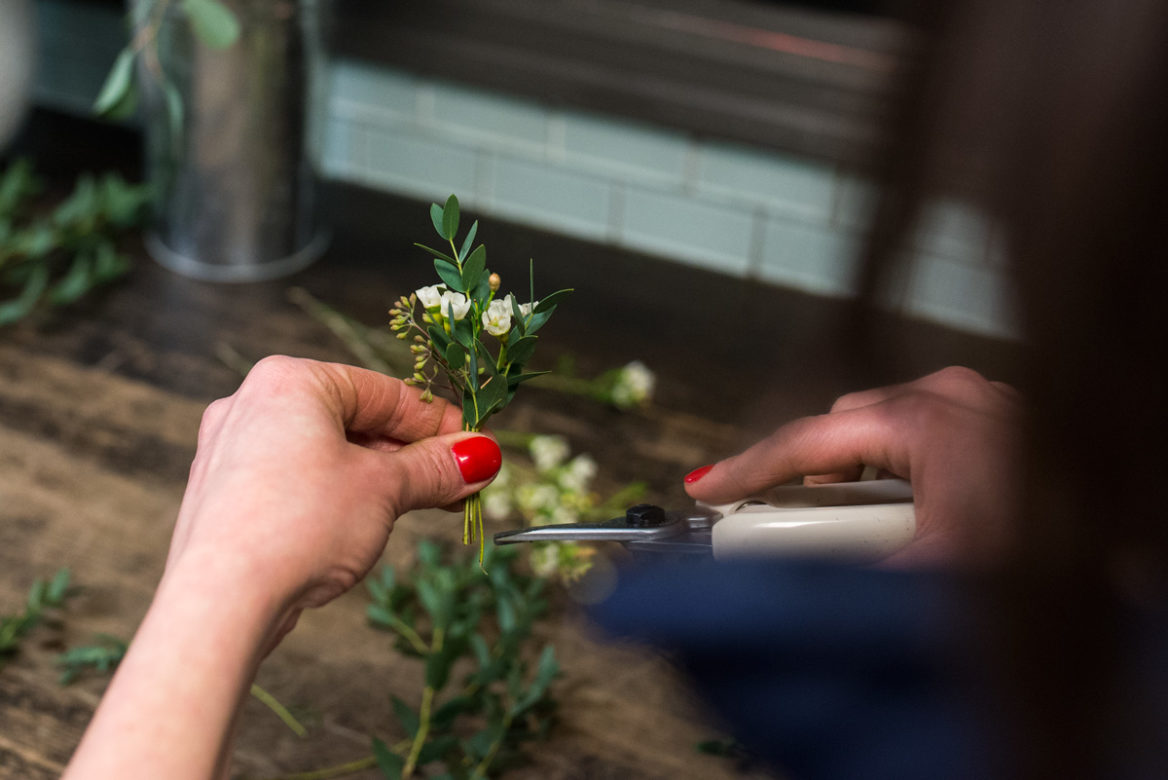 Alex Avdoulos prepares boutonnieres for an upcoming wedding. (Angie Wang for NY City Lens)
