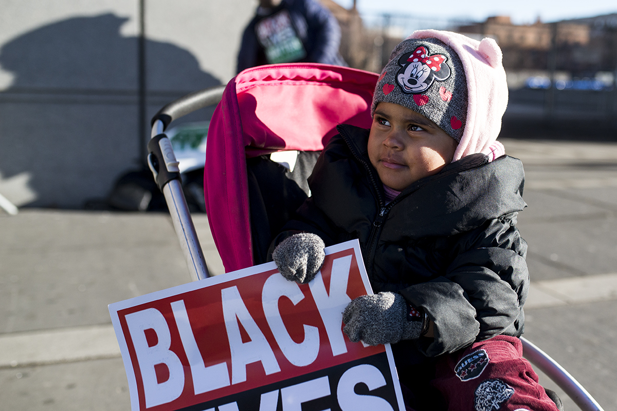 Serenityy, 2, looks toward her mom, Angelique Kearse, who said she brought her daughter to the Black Lives Matter protest because it's important for children to be involved from a young age. (Angie Wang for NY City Lens)