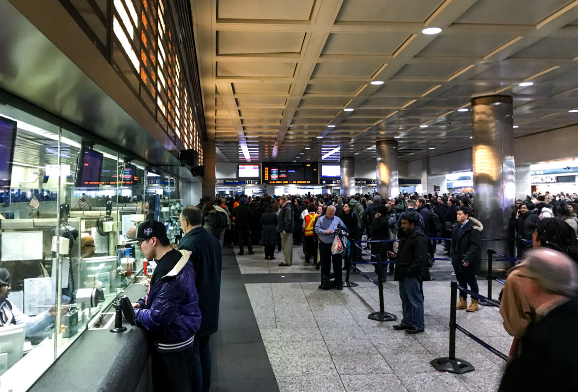 Passengers inquire about LIRR service interruptions at Penn Station Friday evening. (Angie Wang for NY City Lens)