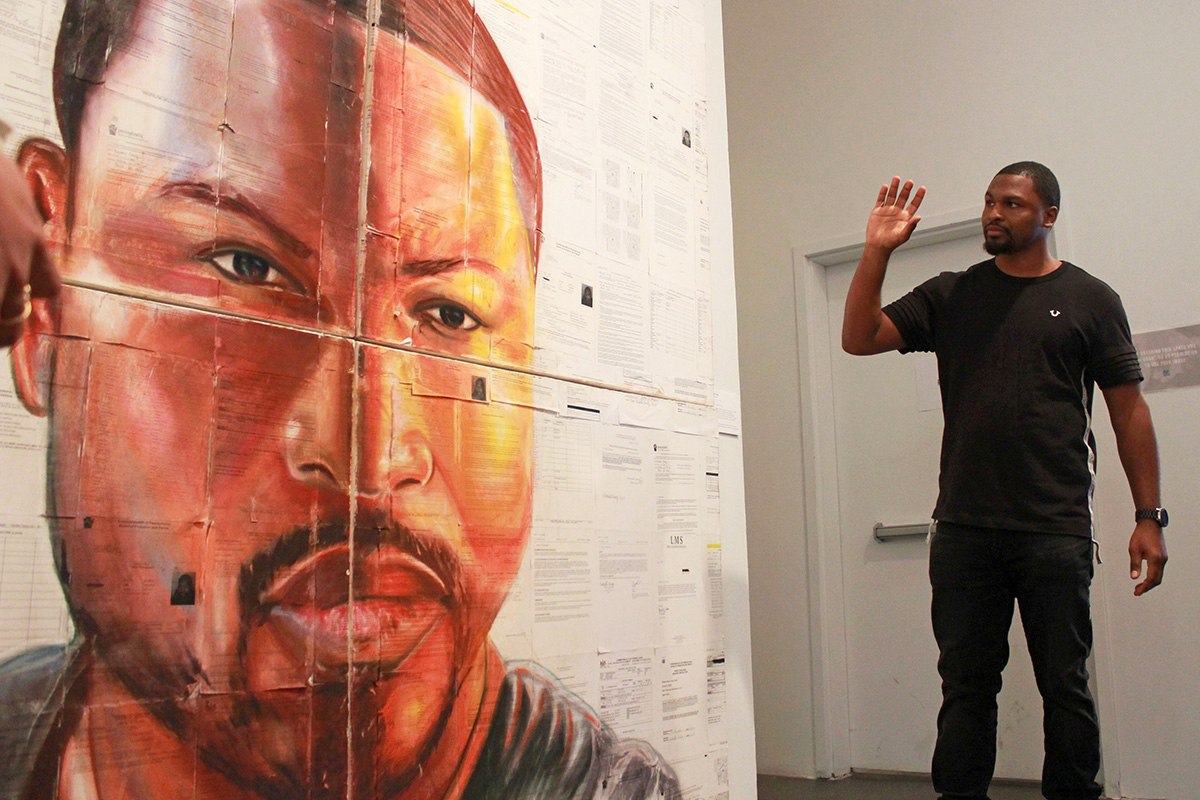 Russell Craig talks about his self portrait, made with pastel on old prison documents. (Emma Vickers/NYCityLens)