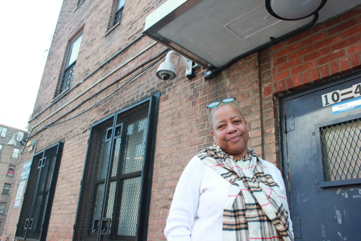 April Simpson, President of the Tenant Association for Queensbridge Houses, stands outside a residential building the in the neighborhood.