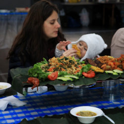 Using hands, toddlers gobbled up Indonesian food with the help of their parents.