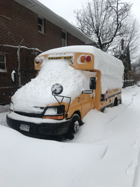A snow-covered school bus outside the PS-117 J. Keld/Briarwood School polling location in Jamaica, Queens.