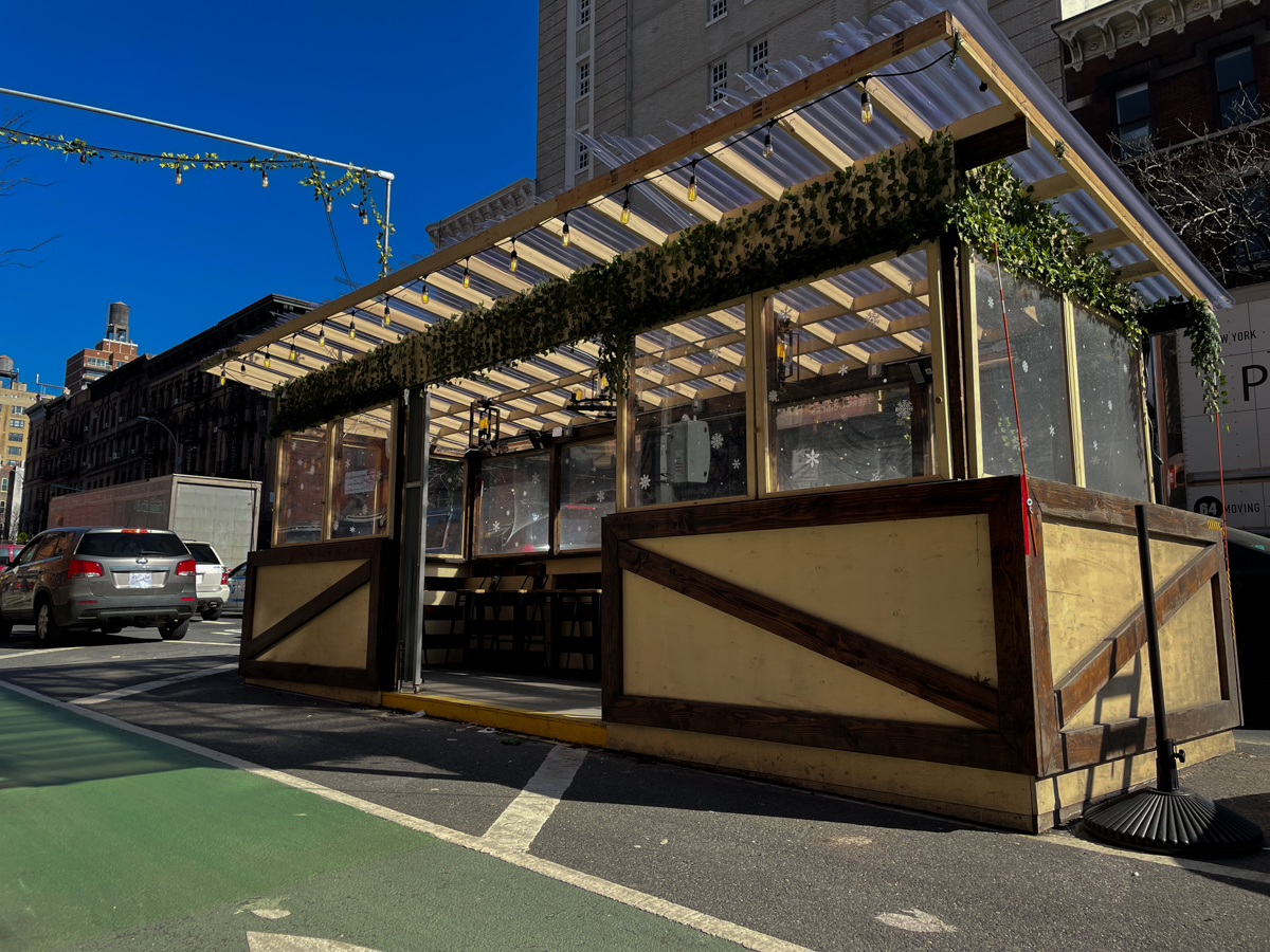 An outdoor dining shed on Amsterdam Avenue equipped with a television and heat lamps in New York on Feb. 9, 2022. The Department of Transportation said on Tuesday it does not envision sheds in outdoor dining's post-Covid future. Credit: Luke Cregan for NY City Lens.