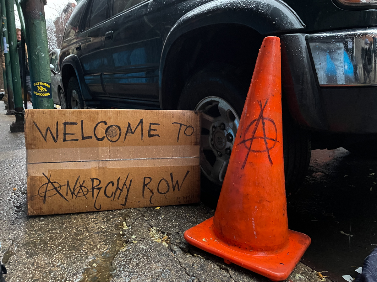 A sign reading “Anarchy Row” near a row of tents on the Lower East Side on Wednesday, April 6, 2022. Credit: Luke Cregan for NY City Lens.